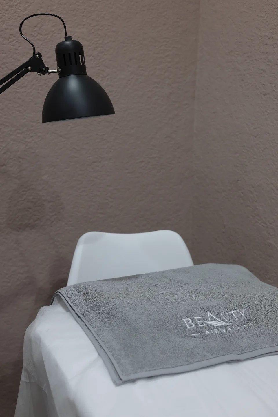 A prepared, empty lash treatment bed with a Beauty Airways towel
