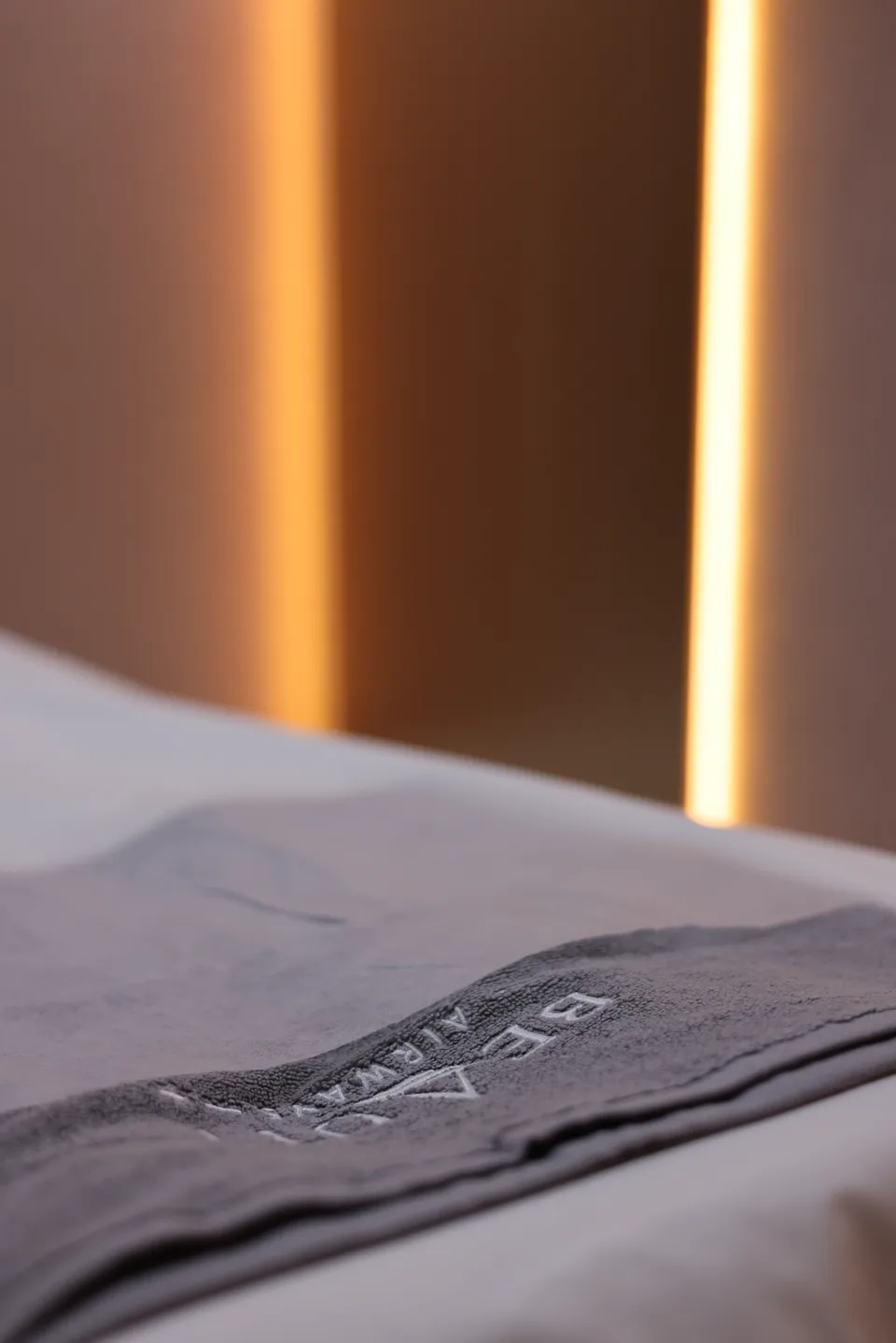 A Beauty Airways towel on a prepared bed beside warm lighting in a private treatment room